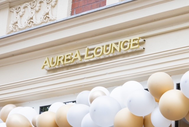 Golden Auréa Lounge lettering above the entrance, with balloons below